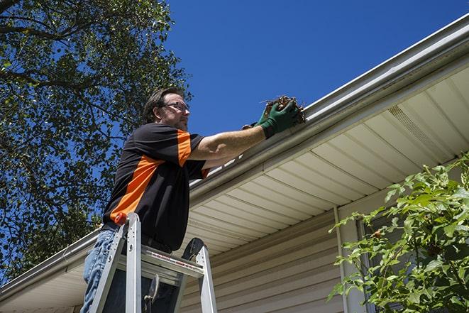 repairman using a ladder to access a damaged gutter for repair in Antelope CA