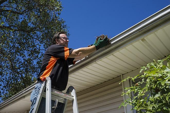 a technician fixing a damaged gutter system in West Sacramento